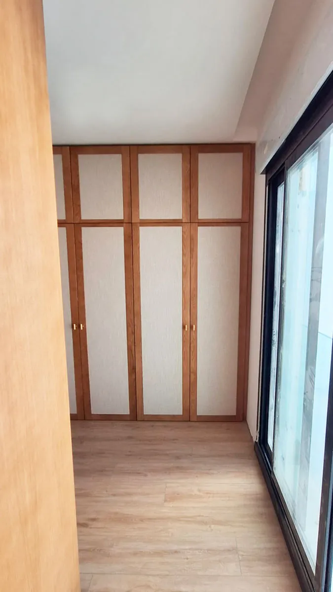 Un vestidor artesanal: con puertas enmarcadas de roble y lino