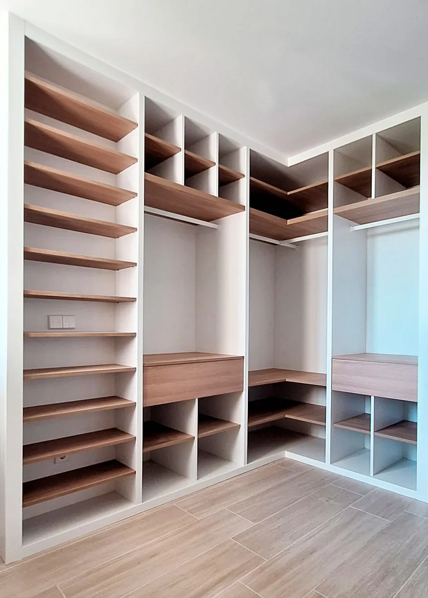 Un vestidor que combina madera y blanco