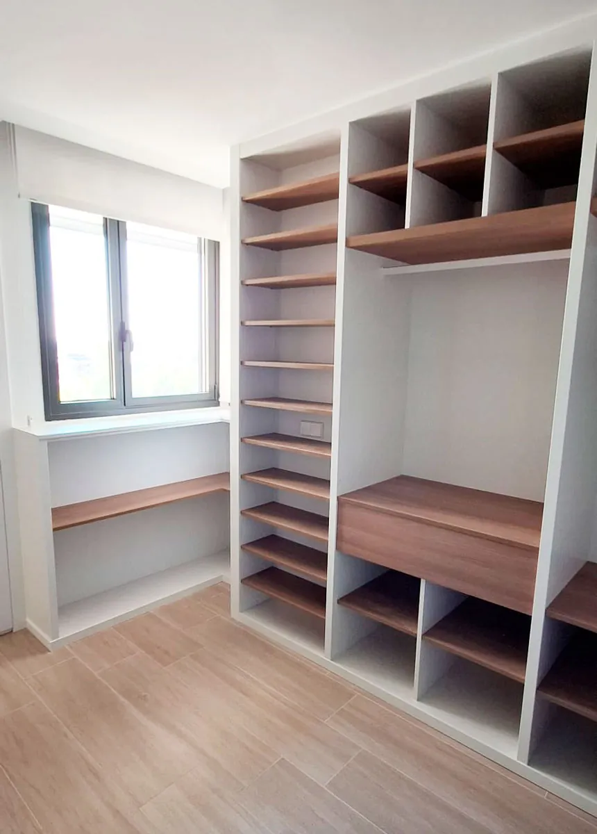Un vestidor que combina madera y blanco