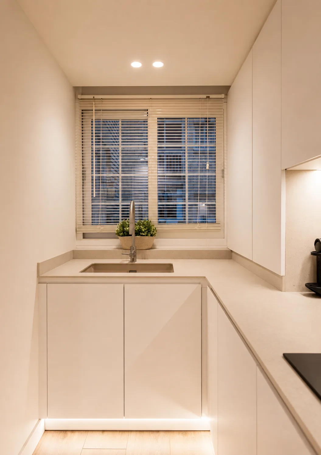 Una cocina blanca abierta diseñada para aprovechar cada centímetro