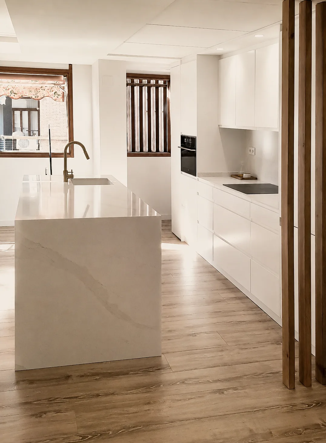 Cocina blanca abierta al salón con isla y lavadero integrado