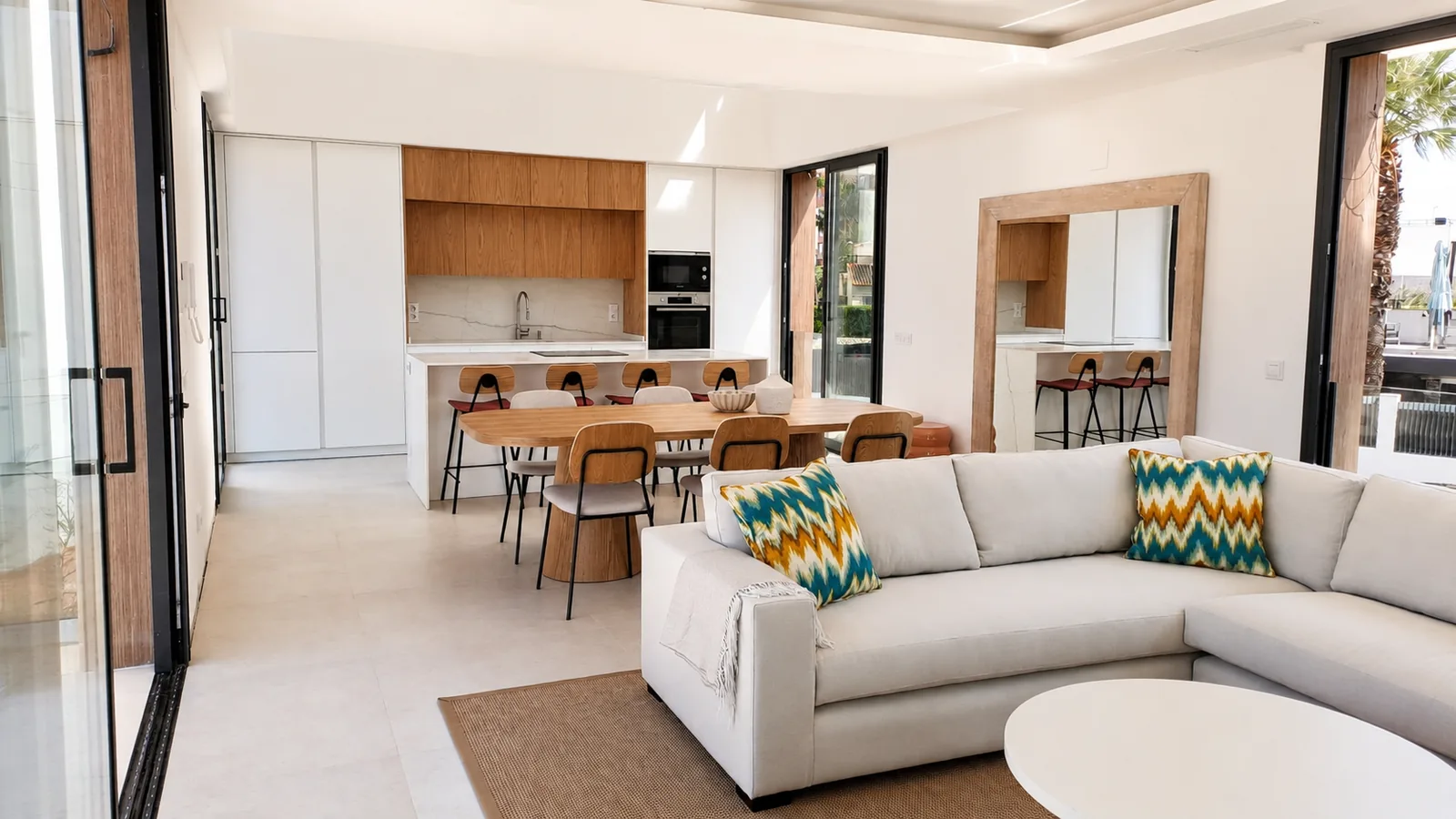 Una cocina blanca y de roble abierta a un espacio lleno de luz