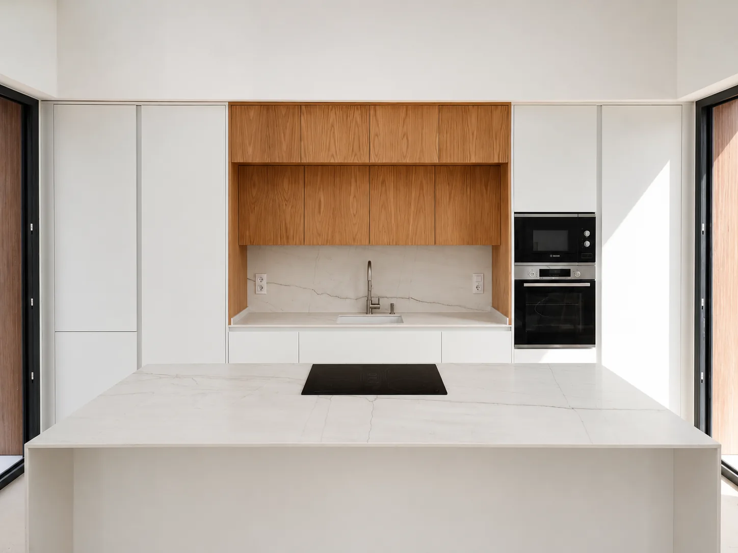 Una cocina blanca y de roble abierta a un espacio lleno de luz