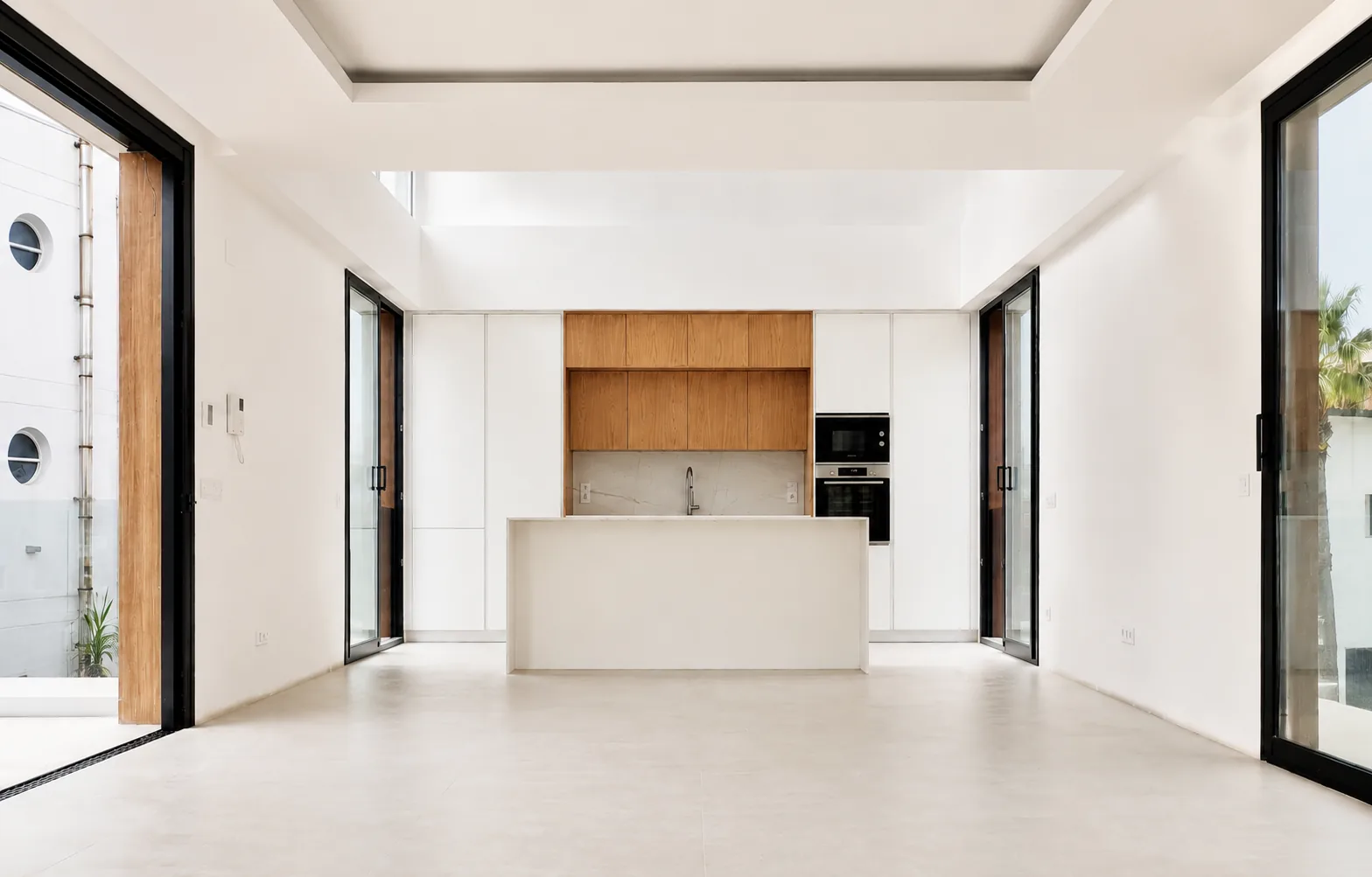Una cocina blanca y de roble abierta a un espacio lleno de luz