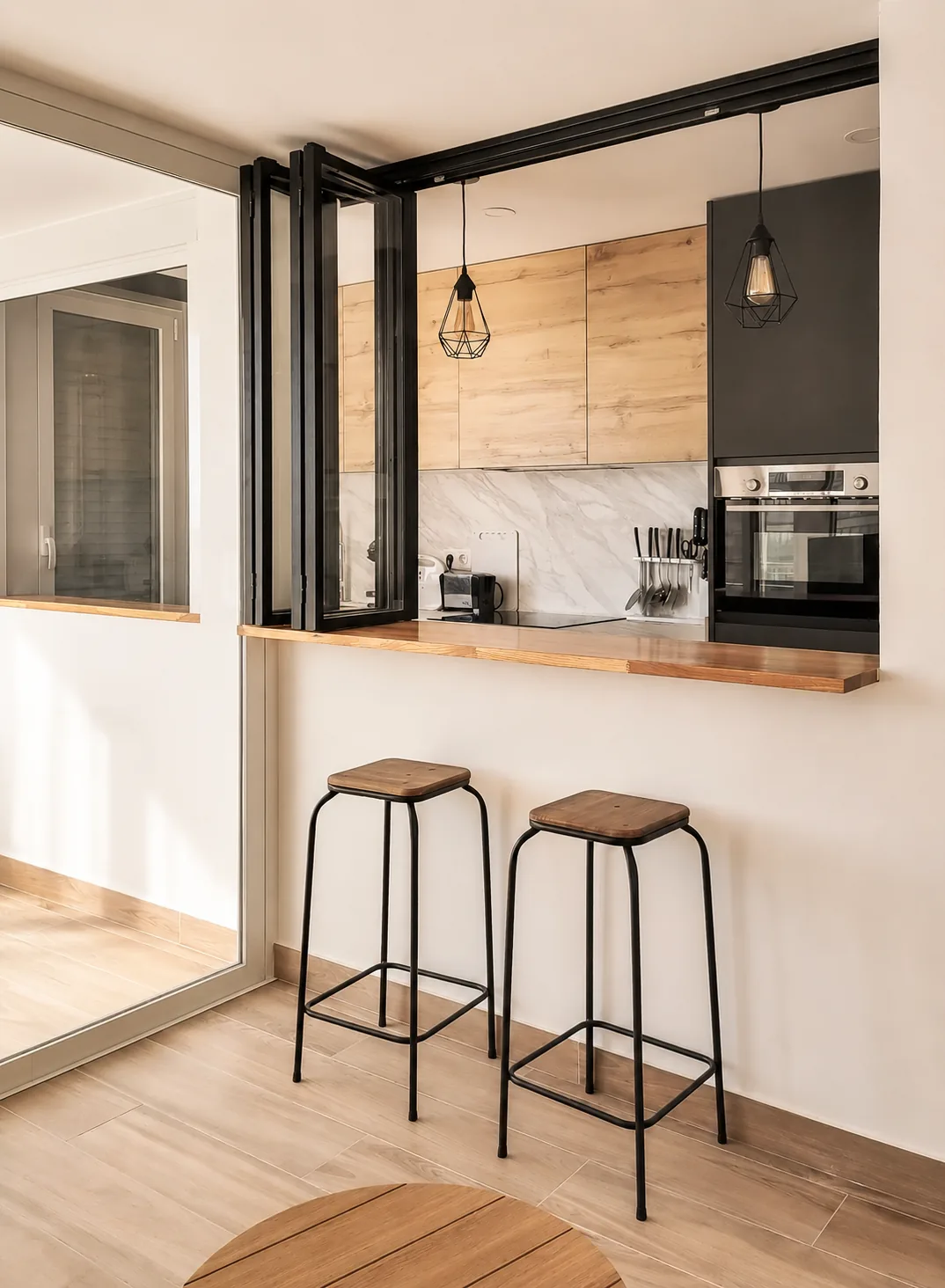 Una cocina compacta abierta al salón mediante un cerramiento plegable