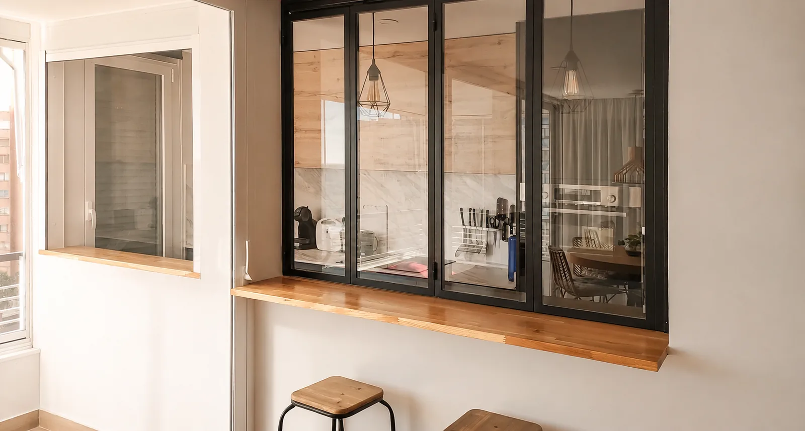 Una cocina compacta abierta al salón mediante un cerramiento plegable