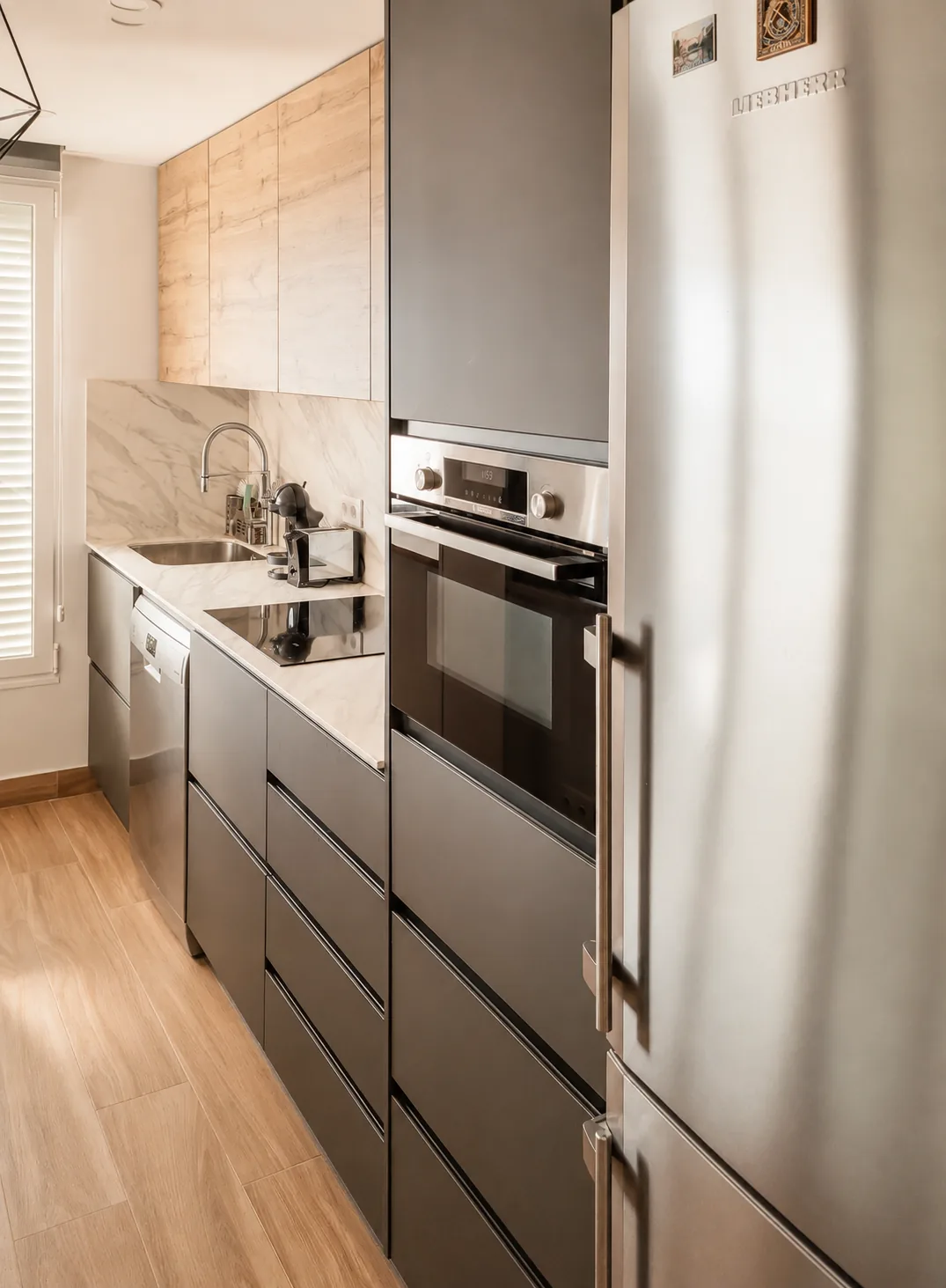 Una cocina compacta abierta al salón mediante un cerramiento plegable