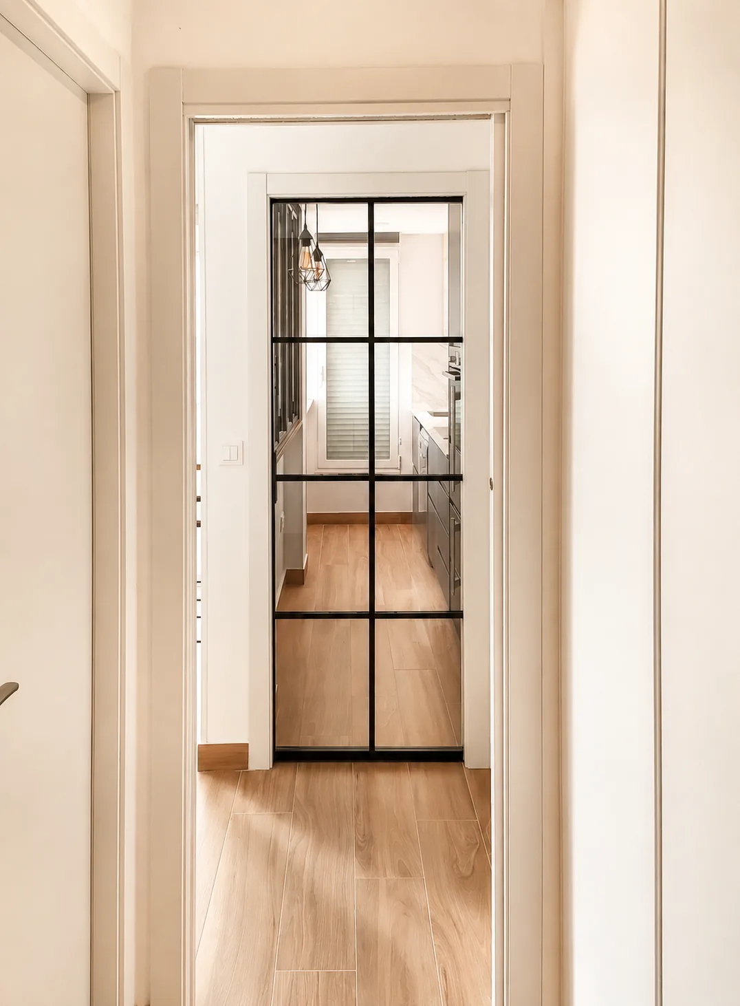 Una cocina compacta abierta al salón mediante un cerramiento plegable
