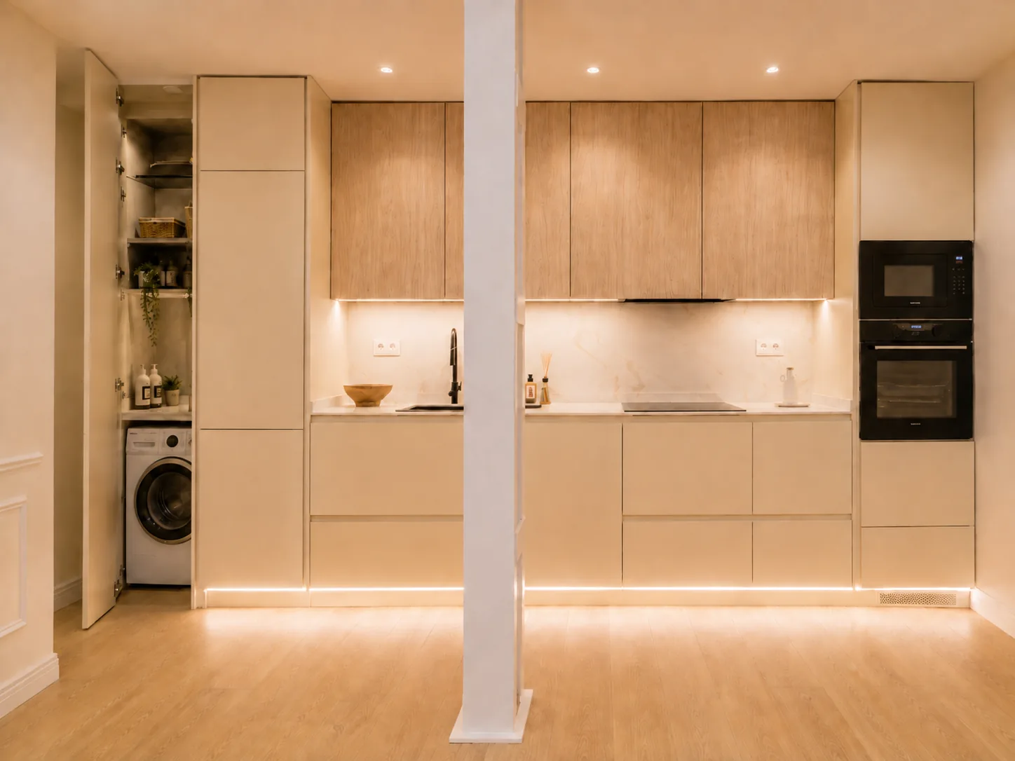 Cocina integrada en el pasillo con acabados en madera clara y crema