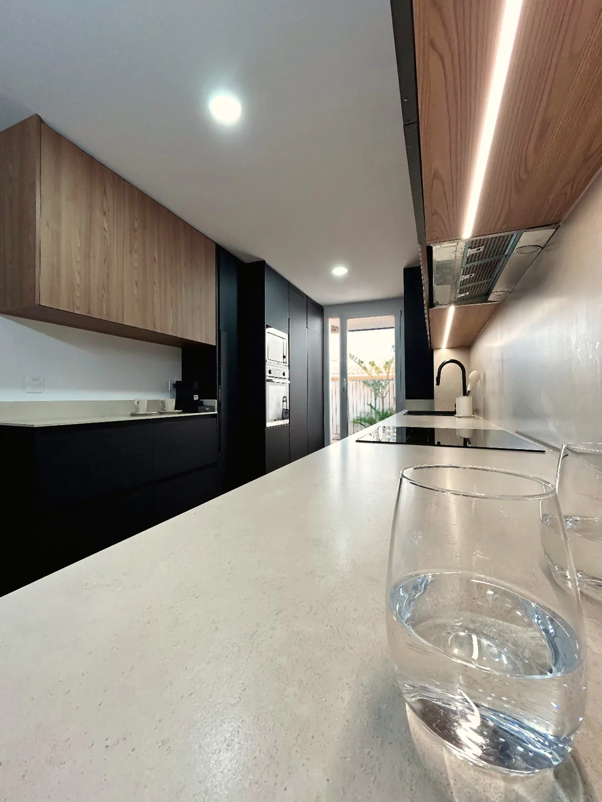 Una cocina negra mate con madera, pensada para tenerlo todo